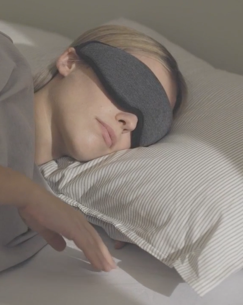 a woman sleeping wearing an eye mask