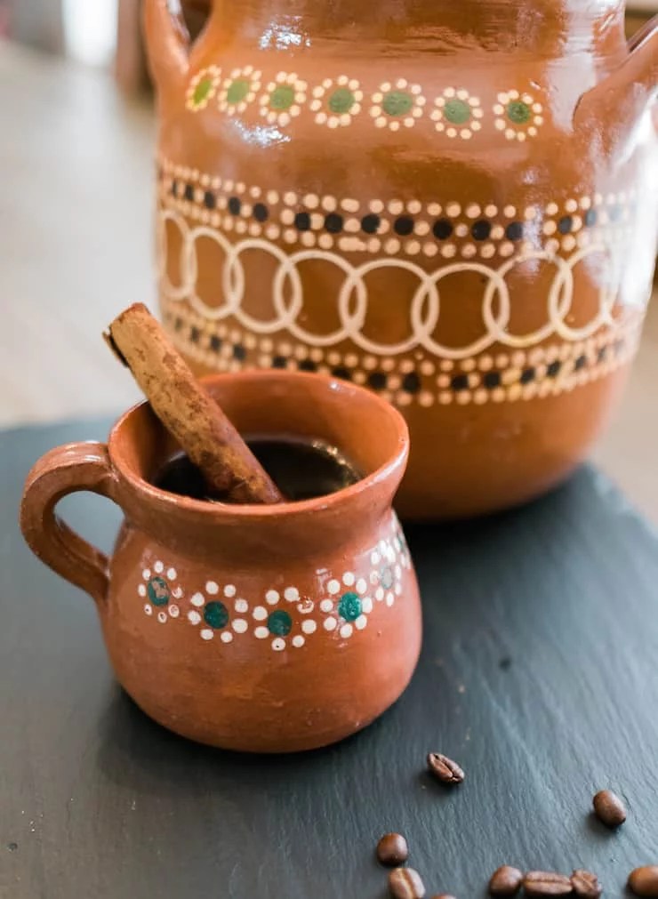 Café de Olla in a decorative clay pot with a cinnamon stick