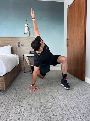 Personal trainer demonstrating active runner's lunge with T-spine rotation