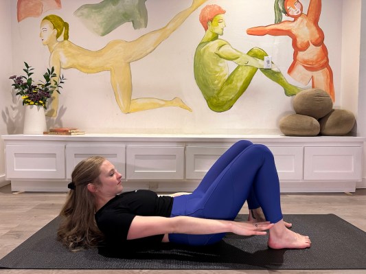 Pilates instructor demonstrating 100 Pilates exercises with feet on the floor