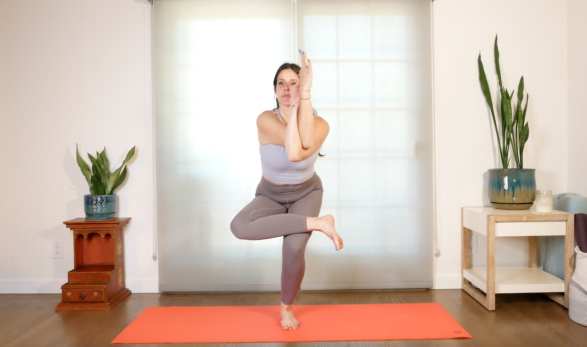 professora de ioga demonstra como tornar confortável a postura da águia na ioga se você estiver no pré-natal, colocando a perna em uma figura 4 