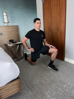 Personal trainer demonstrating static hip flexor stretch