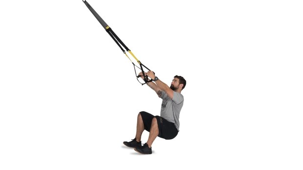 Person demonstrating a TRX squat row 