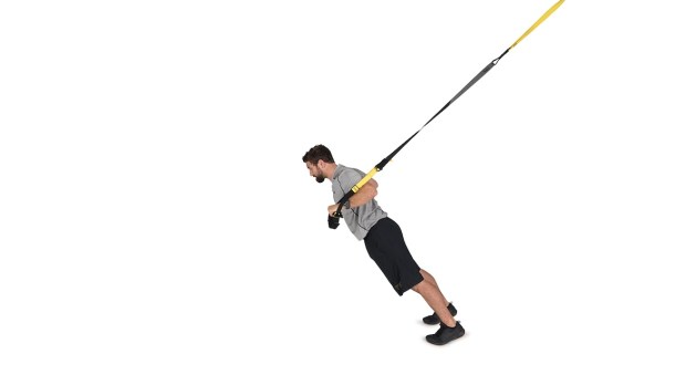 Person demonstrating TRX chest compressions as part of a TRX workout 