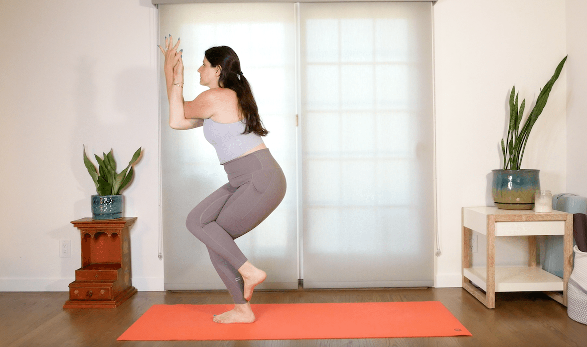 yoga teacher demonstrates how to perform eagle pose in yoga 