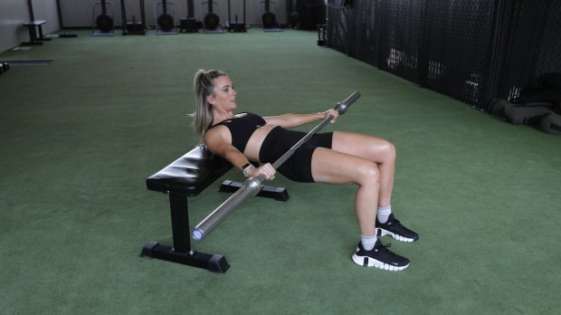 Personal trainer demonstrating barbell hip thrust