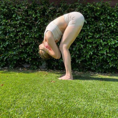 Professor de ioga demonstrando dobra para frente em pé para ioga para dor no pescoço