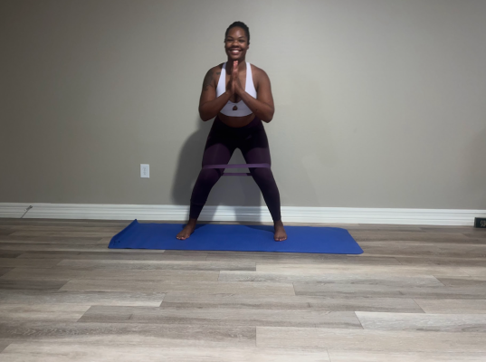 Personal trainer demonstrating banded lateral (monster) walk