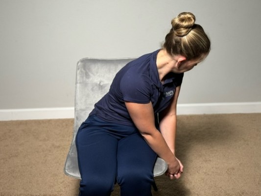 Physical therapist demonstrating chop pattern stretch as best trapezius stretches