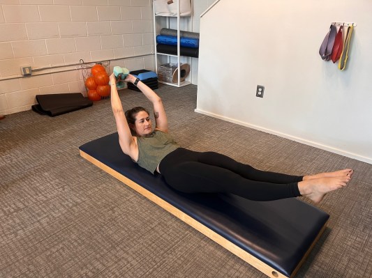 Pilates instructor demonstrating double-leg stretch