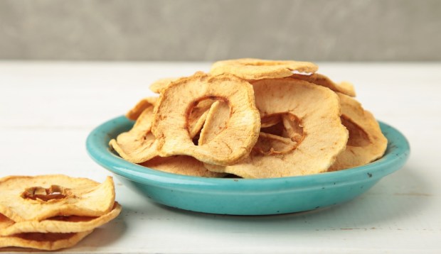 dried apple chips in blue bowl on white table