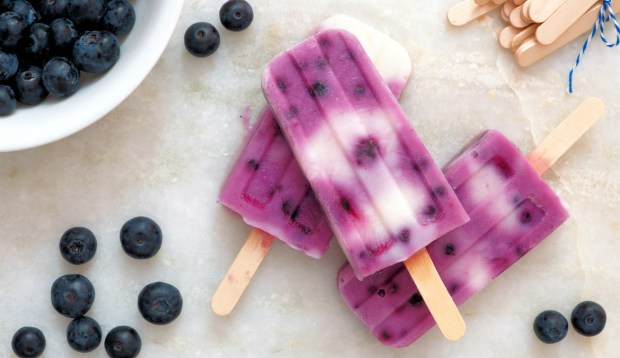 berry and vanilla popsicles lying on white background