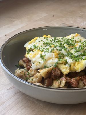 Close up image of scrambled pancakes mixed with chorizo, egg, cheese, and chives