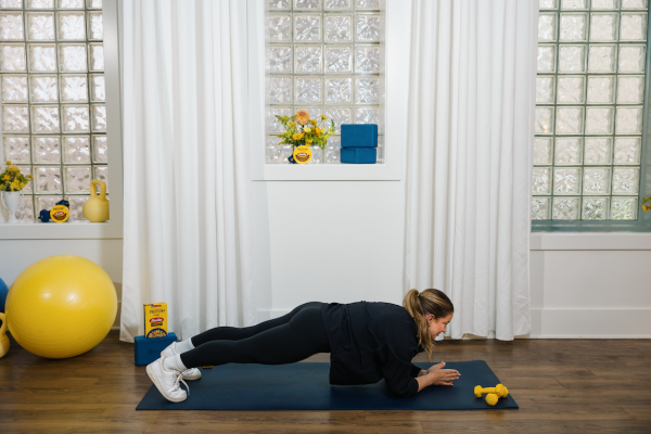 Shawn Johnson East demonstrating forearm plank as part of an at-home workout