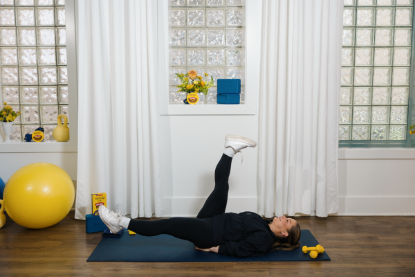 Shawn Johnson East demonstrating scissor kicks as part of at-home workout