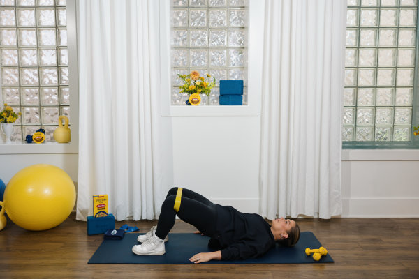 Shawn Johnson East demonstrating at-home workout banded glute bridge