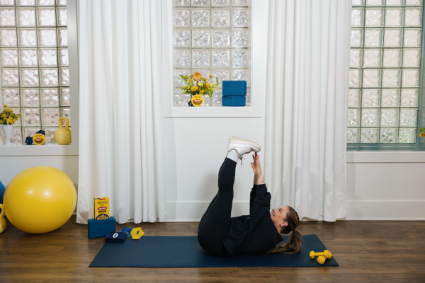 Shawn Johnson East demonstrating toe touch as part of at-home workout