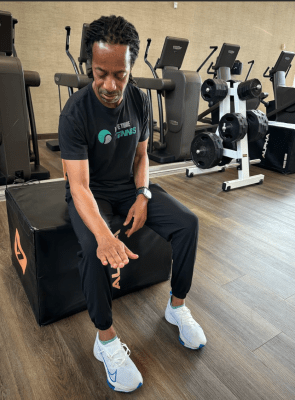 Tennis coach demonstrating tennis elbow prevention exercise