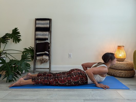 Yoga teacher demonstrating incorrect way to do cobra pose