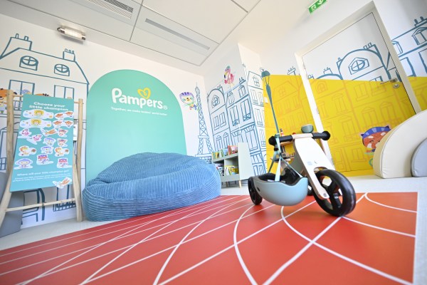 The Olympic Village Nursery play area, including a racing play mat, tricycle, and bean bag chair.