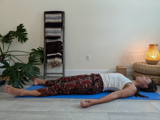 Yoga teacher demonstrating correct way to do corpse pose