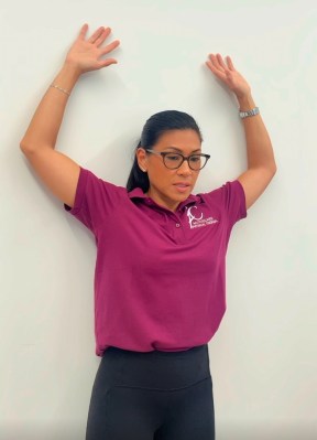 Physical therapist demonstrating the wall angels exercise