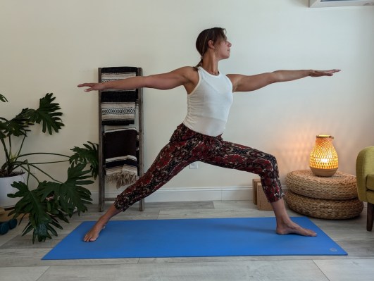 Yoga teacher demonstrating incorrect way to do warrior II pose