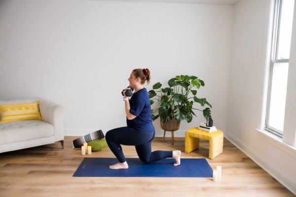 Personal trainer demonstrating alternating reverse lunge to biceps curl