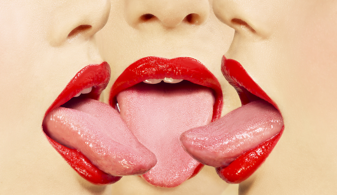 An image of three mouths with their tongues out and almost touching. The lips on each mouth are wearing red lipstick and the rest of each face is cut off above the nostrils. This photo is being used to promote an article about tongue vibrators