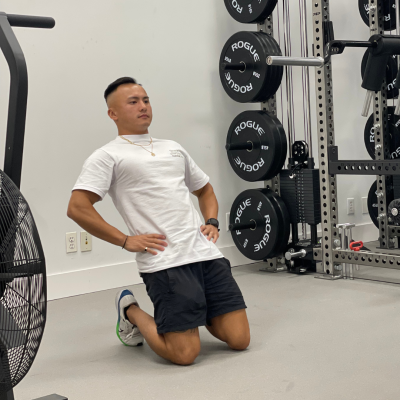 Physical therapist demonstrating reverse Nordic curl