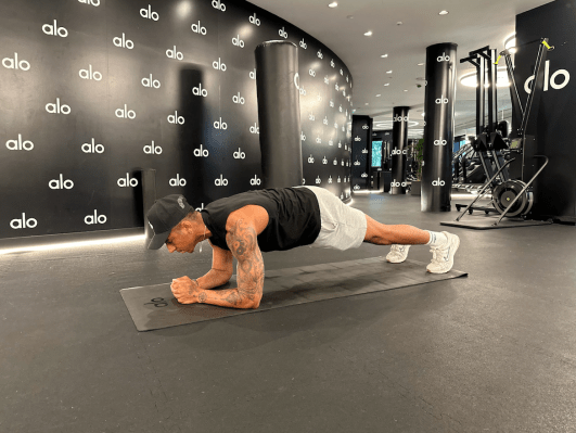 Personal trainer demonstrating forearm plank