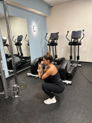 Personal trainer demonstrating cable Zercher squat