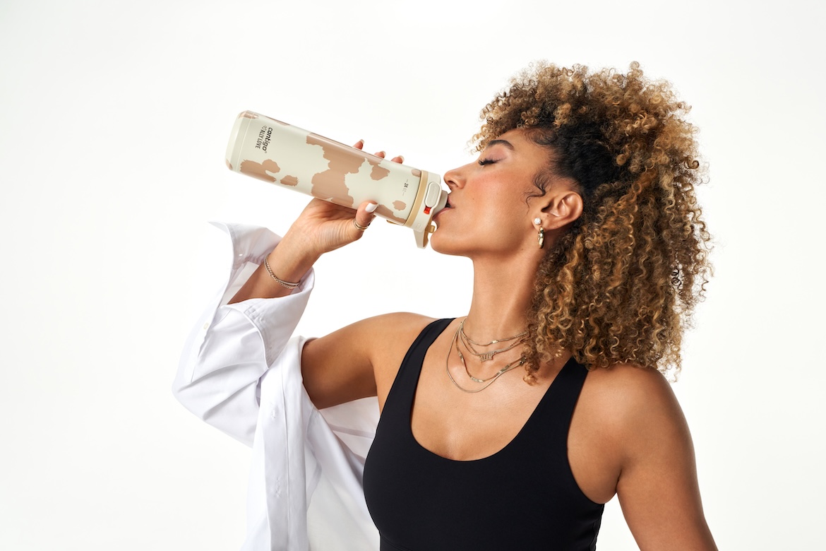 Peloton instructor Ally Love drinking from a Contigo water bottle on white background