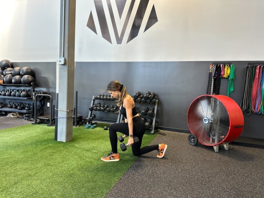 Personal trainer demonstrating dumbbell lunge