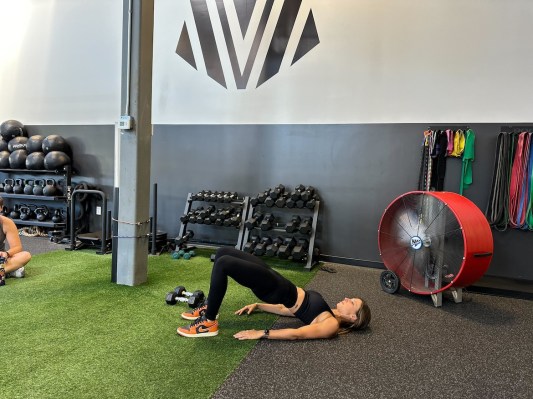 Personal trainer demonstrating glute bridge