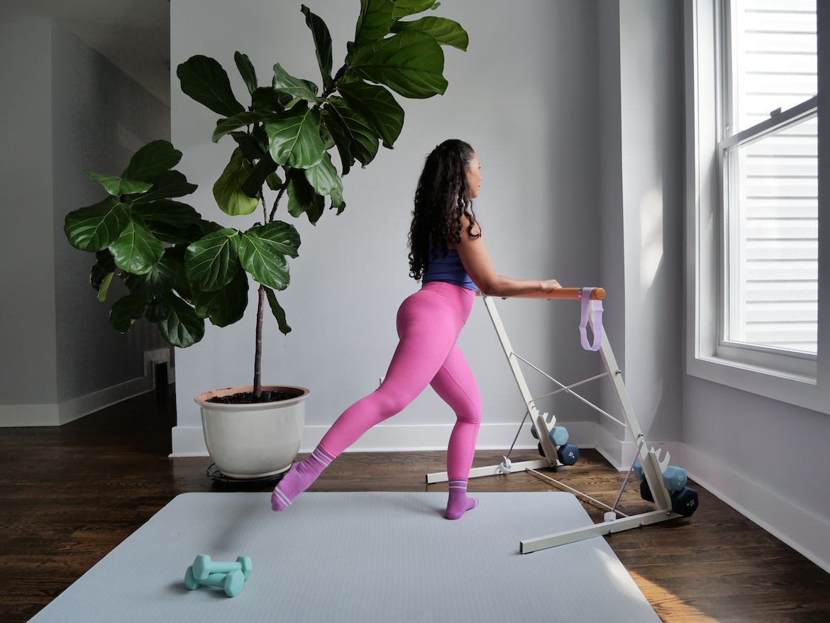 Barre instructor demonstrating standing bent leg