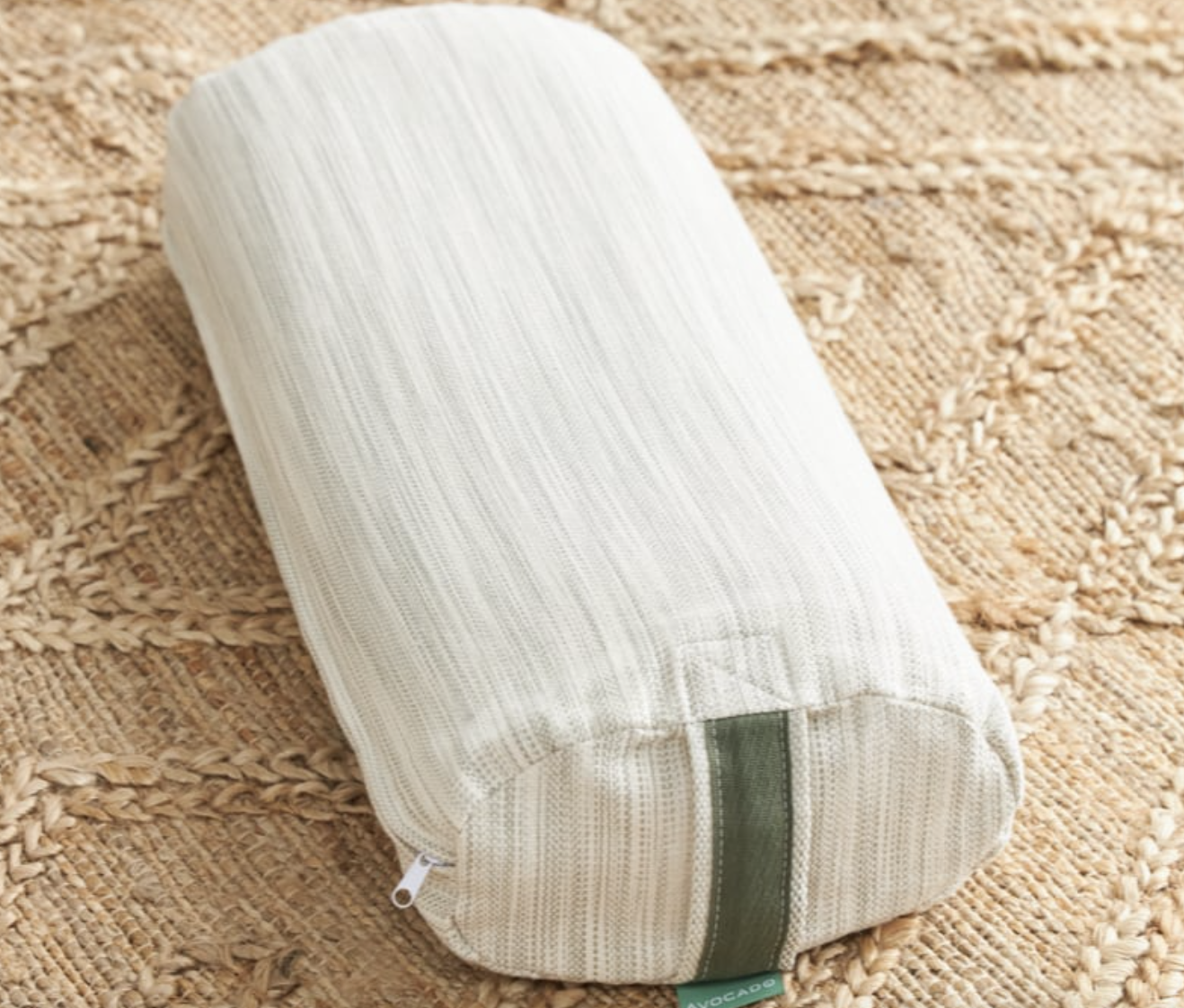 Photo of organic yoga bolster pillow with white avocado brand on tan background