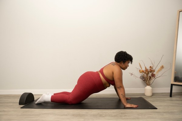 Pilates instructor demonstrating kneeling plank