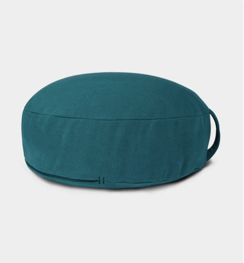 Photo of a green Manduka Enlight Meditation Cushion on gray background