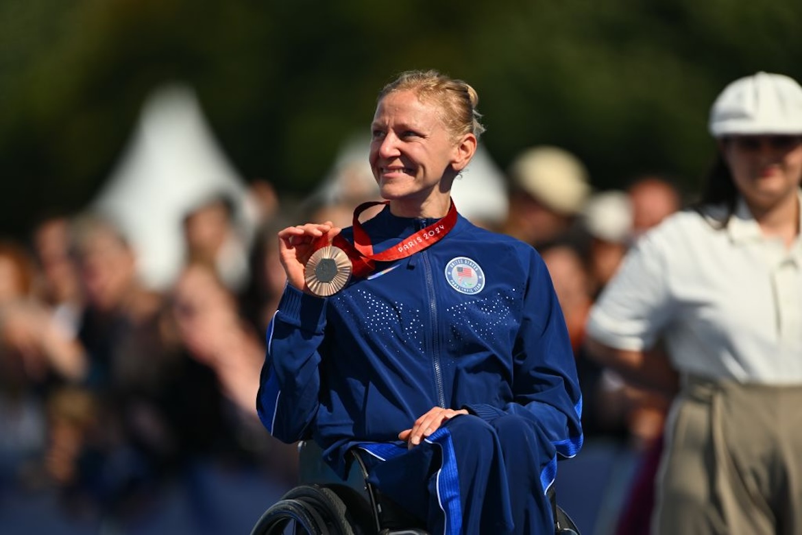 Photo of pro wheelchair racer Susannah Scaroni wearing bronze Paralympic medal around her neck