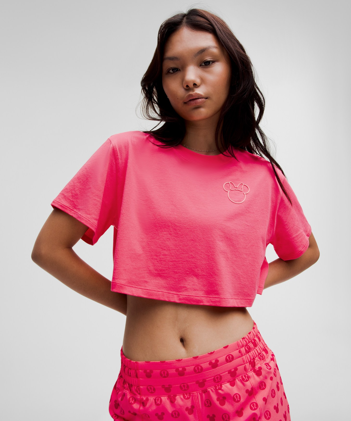 A woman wearing a hot pink crop top shirt.