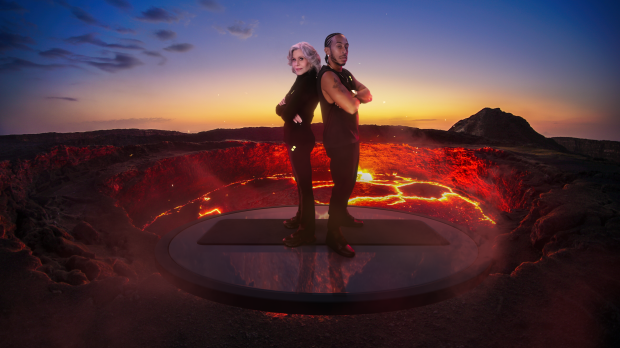 Jand Fonda and Ludacris stand atop a smoldering volcano at sunset.