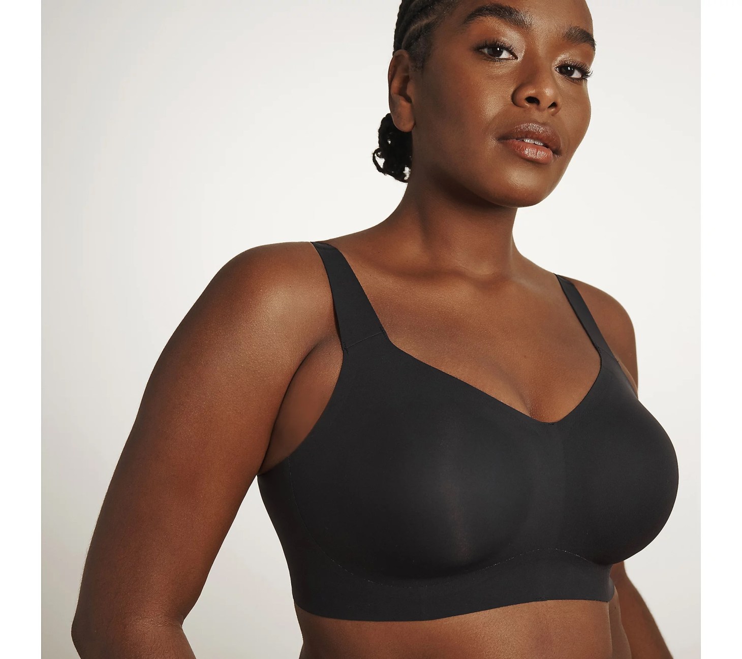 A woman wearing a black seamless bra seen from a 3/4 view.