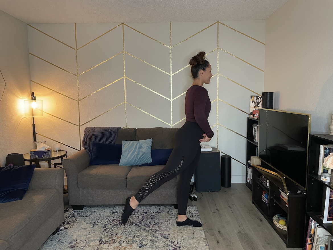 Personal trainer demonstrating arabesque lift barre exercise